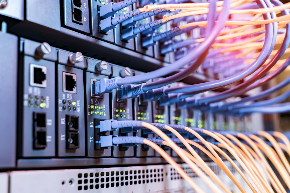 server rack with fiber optic cables attached to front panel swit